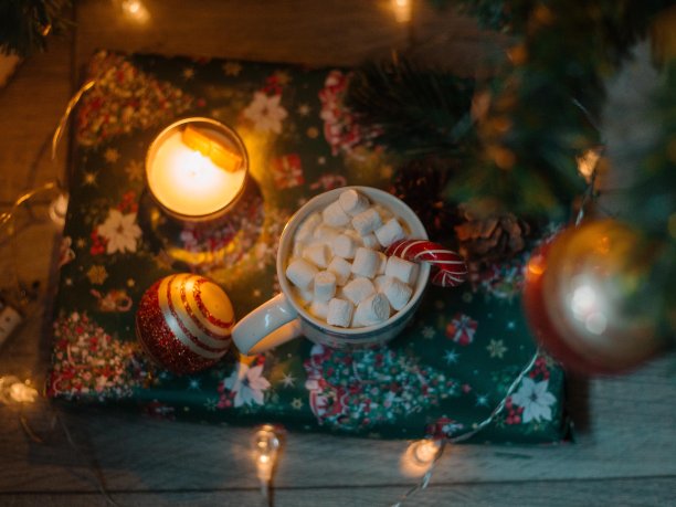 新年拐杖糖与可可和棉花糖一起放在杯子里，背景是舒适的圣诞圣诞树礼物和圣诞球。糖果和圣诞礼物。除夕夜图片下载