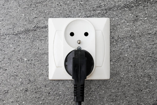厨房柜台电源插座隔离在灰色大理石墙上。石头装饰的厨房。改造的单间公寓供电。图片下载