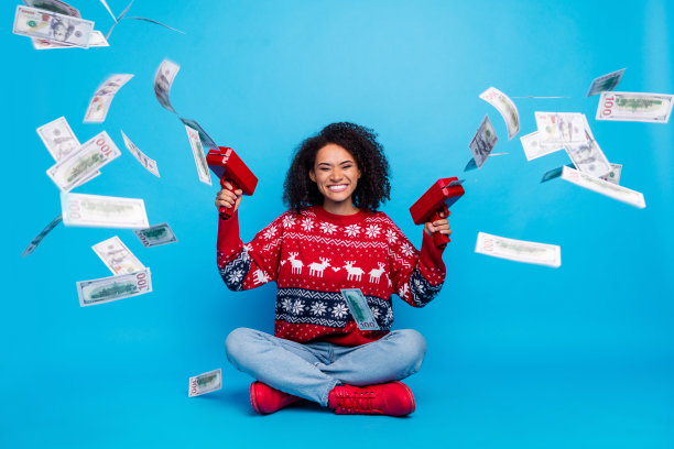 照片积极开朗的女孩有现金返还收入，从银行特别优惠的圣诞节孤立的蓝色背景图片下载