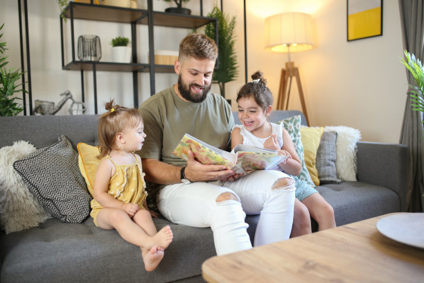 快乐的父亲和女儿在新家里看相册。库存图片图片下载
