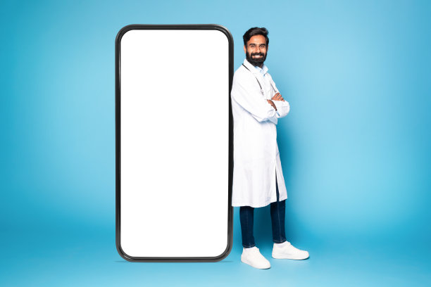 印度男医生靠在带空白屏幕的巨大智能手机上图片下载
