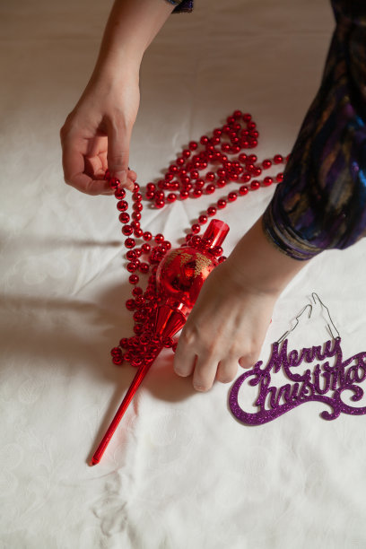 双手捧着白色表面上的红花环图片下载