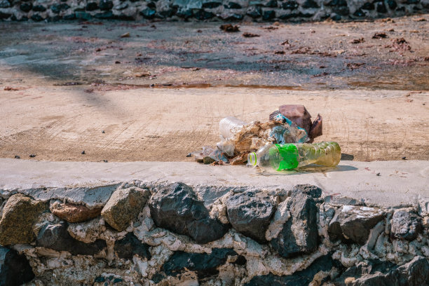 从海边收集的塑料垃圾留在水泥人行道上。特写照片图片下载
