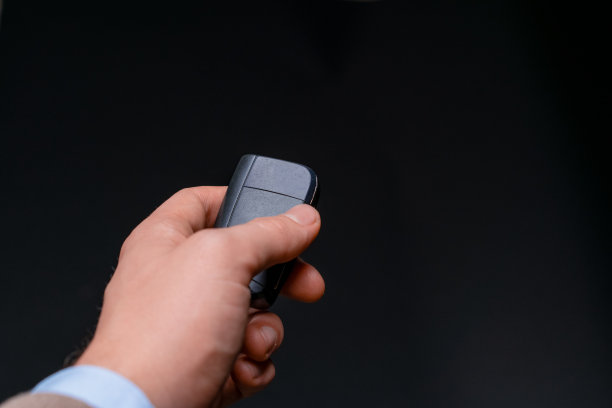 汽车销售员将新电动汽车的车钥匙交给买家。黑色背景的工作室环境。图片下载