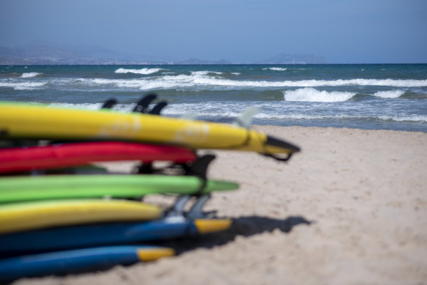一组不同颜色的冲浪板按顺序堆叠在一起。沙滩上学校用的冲浪板。柔和色调的照片。图片下载
