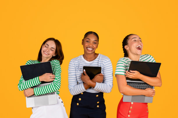 激动的年轻多种族女性抱着小玩意，黄色背景图片下载