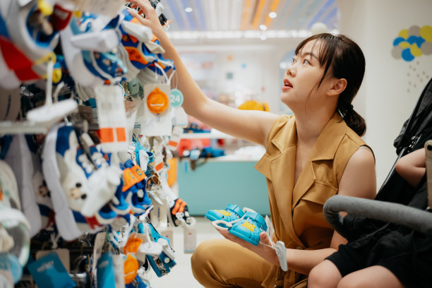 在百货公司选购童鞋的亚洲妇女图片下载