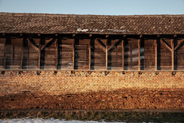 在塞尔维亚伏伊伏丁那省的农村，黄昏时分，在一个遭受农村人口外流的欧洲地区，一个废弃的农场里，旧玉米和谷物烘干机，木结构，正在腐烂。图片下载