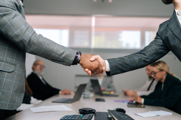 经过剪裁的照片，照片上的非裔美国人和白人商人穿着西装，在谈判成功后握手图片下载