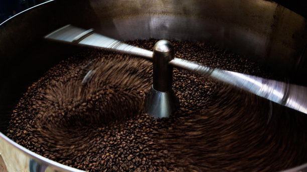 咖啡豆和烘焙纺丝覆盖专业机器，近距离软聚焦，拍摄需要运动和咖啡豆细节概念的低速照片;图片下载