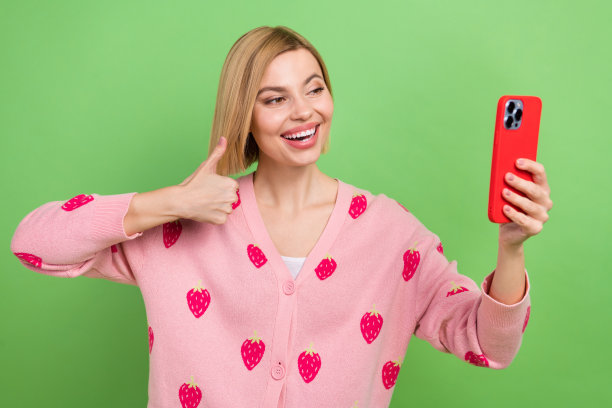 照片的博客年轻有趣的女孩自拍视频相机智能手机推荐质量图片大拇指孤立的绿色背景图片下载