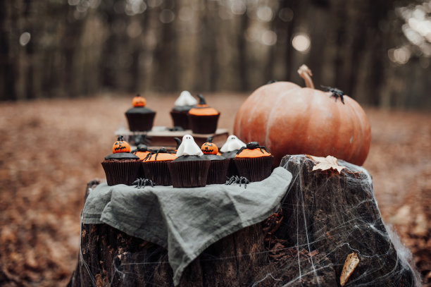 在秋天的户外，万圣节纸杯蛋糕和节日装饰在树上的枫叶图片下载