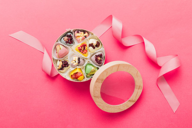 节日构图:甜甜的糖果，带蝴蝶结和巧克力心的礼盒，照片模板，背景。在彩色背景上带有复制空间的俯视图图片下载