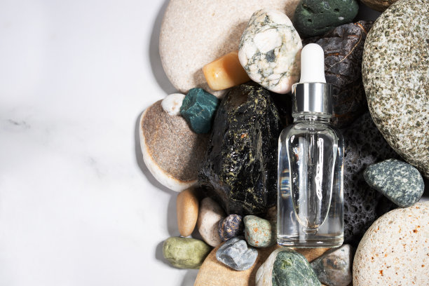 装在石头和鹅卵石里的面膜精华液，保湿精华液，抗衰老，面部化妆品，复制空间图片下载