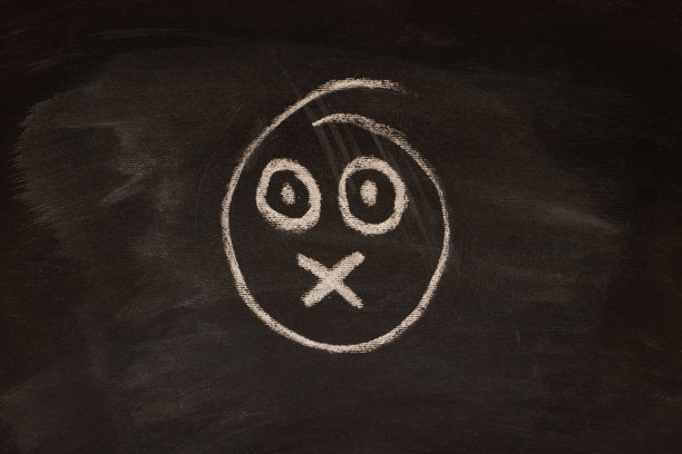 用粉笔在黑板上画的吓人的表情符号。图片下载