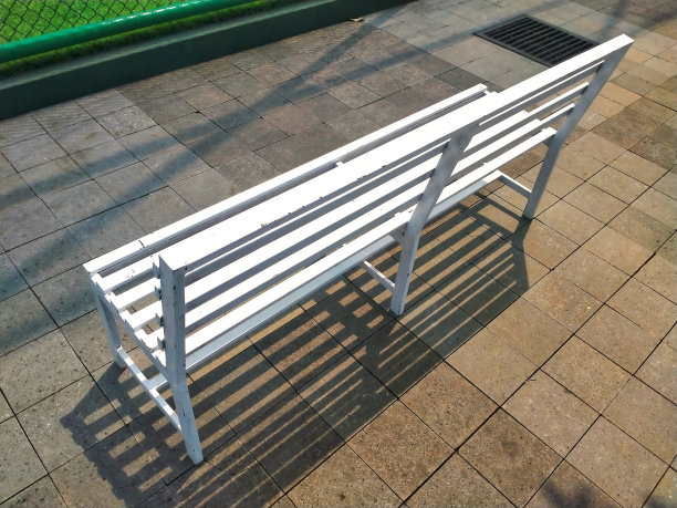 足球场围栏外的白色长凳图片下载