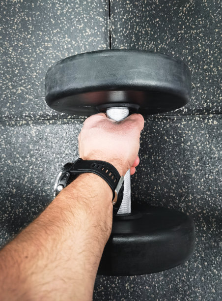 健身房里一个男人手里拿着哑铃，特写照片。图片下载