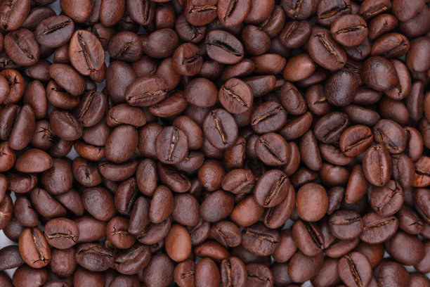 白色的桌子上散落着咖啡豆。高品质的新鲜烘焙咖啡特写照片。俯视图图片下载