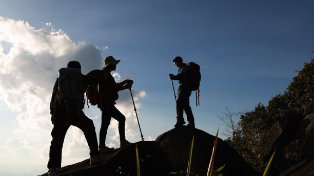吊架三人，徒步到山顶，冒险旅行度假，傍晚在暮色下的小山上徒步旅行。旅行的概念。图片下载