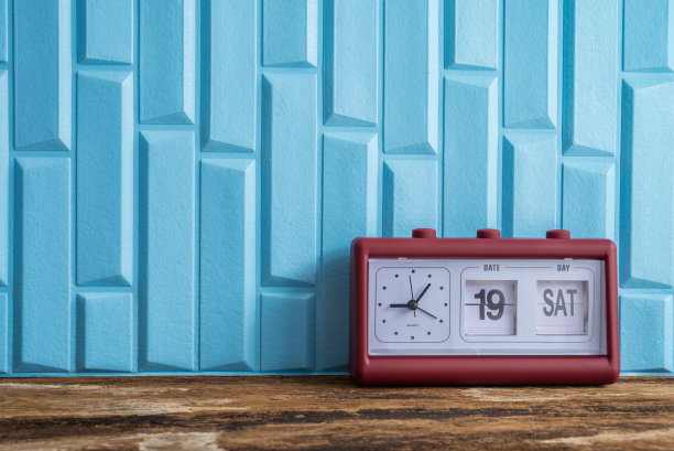 复古风格的红色闹钟与日历日期数字和日期显示在旧木桌。图片下载