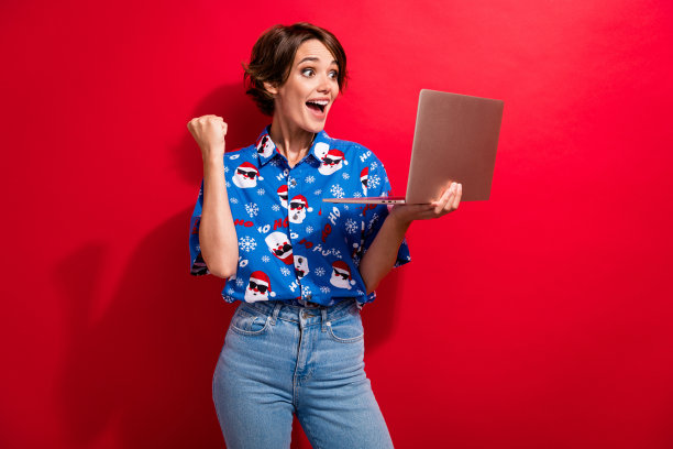 自由职业者女孩年轻时的照片欢呼得到报酬假期拿着笔记本电脑去年新年团队会议孤立在红色背景上图片下载