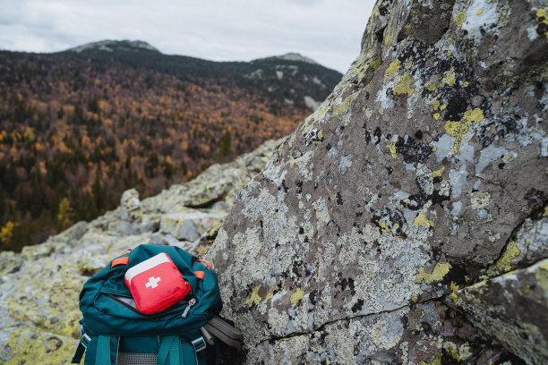 背包上的小型急救箱，山上的安全概念，在岩石上徒步旅行，独自徒步旅行。图片下载