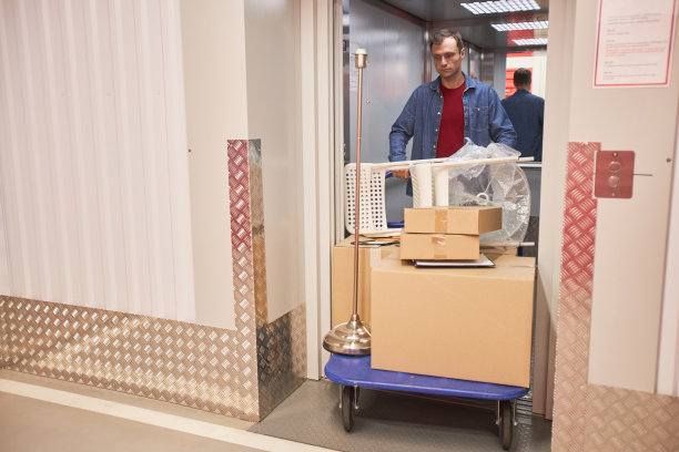 一名男子将购物车推出电梯图片下载