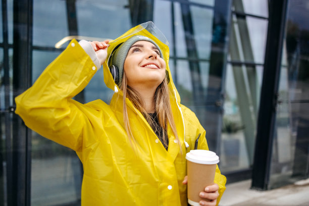 女人在下雨天穿着黄色雨衣去上班图片下载