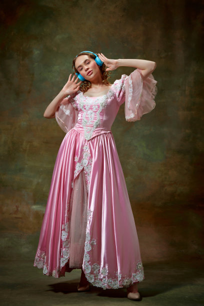 可爱的金发女孩穿着花哨的粉红色连衣裙，在复古的纹理背景上听音乐。现代的公主图片下载