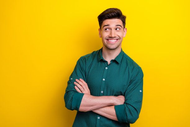 开朗友好的男人穿着时髦的衣服，在黄色的背景上看空的广告牌黑色星期五的照片图片下载