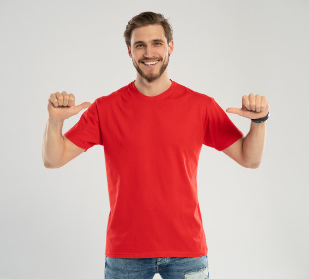 衣服模板。快乐的人指着红色t恤，标志或品牌设计的模型。图片下载