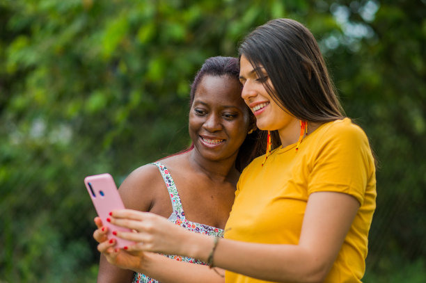 几个女人在公园里用手机分享照片，自拍图片下载