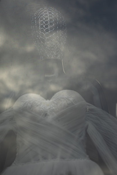 玻璃后面的雕塑。云在玻璃中的反射。没有脸的背影。模模糊糊的人体模型剪影。图片下载