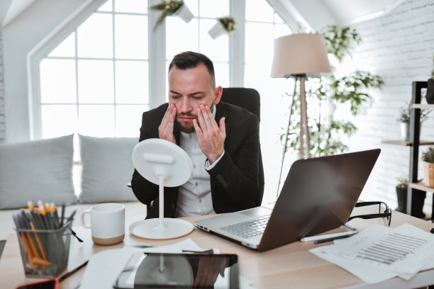 疲惫的商人在开会和喝咖啡前检查他的眼袋图片下载