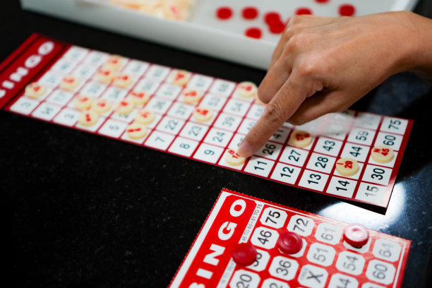 一群家庭成员在家里度假时在客厅的桌子上玩宾果游戏的照片。图片下载