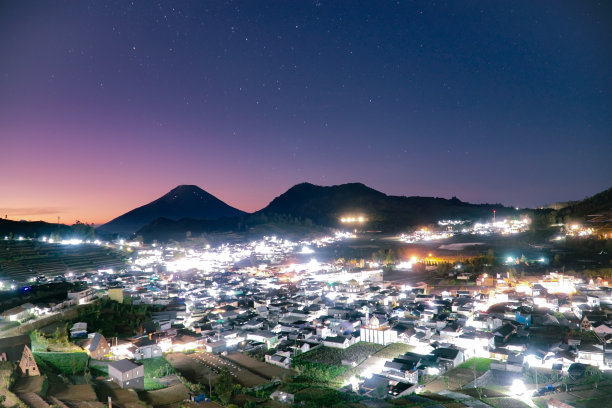 城市之光建筑在Dieng摄政与美丽的日出天空和山图片下载