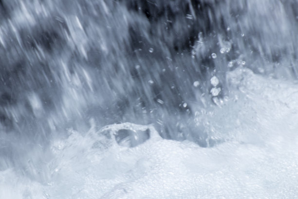 瀑布的特写照片，水滴和白色泡沫从岩石上倾泻而下图片下载