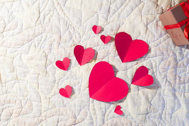 情人节礼物放在床上，白色的被褥和红色的爱情。图片下载