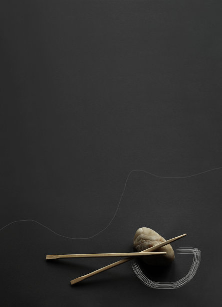 深灰色背景上的日本竹筷和轻石。照片处理-精心绘制的碗轮廓。极简主义，线条，独特的设计，角落构图，宽的复制空间。没有人图片下载