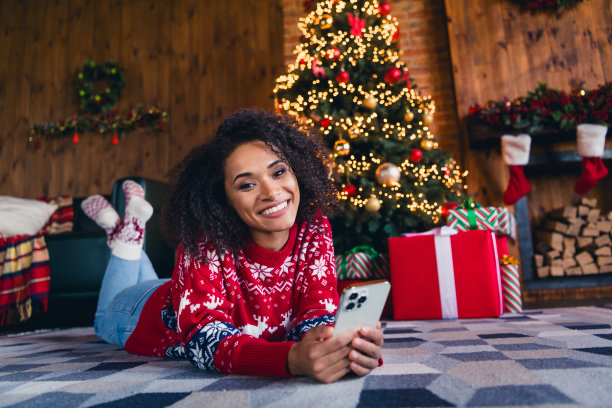照片中，开朗可爱的女孩穿着红色装饰的套头衫躺在地板上，在装修过的家中度过周末图片下载