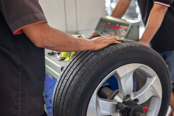 机械师在汽车维修站表演汽车车轮平衡和刺激的照片图片下载