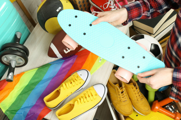在室内，手持滑板的女子靠近许多不同的东西。现场旧货出售图片下载