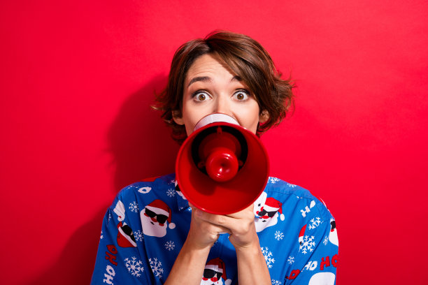 印象深刻的尖叫活动家有趣的女孩拿着麦克风扬声器宣布新年晚会开始孤立的红色背景的照片图片下载