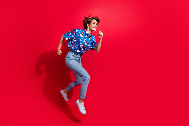 喜出望外的快递小女孩的全身照片送幸福新年来临派对戴鹿角孤立在红色背景图片下载