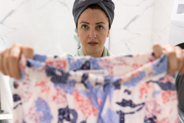 满脸雀斑，头上裹着毛巾的美女，洗衣日。周末心情和放松时间在家里为她，库存照片。炫耀他干净的衣服图片下载