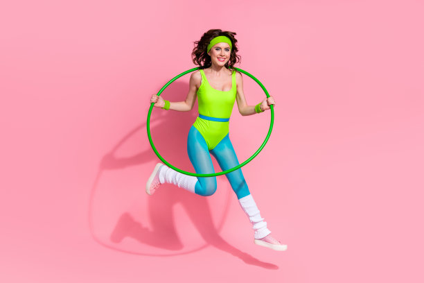 照片有趣的积极的女士运动教练跳做普拉提练习呼啦圈孤立在柔和的颜色背景图片下载