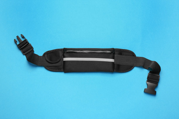 时尚的黑色腰袋在浅蓝色的背景，顶视图图片下载