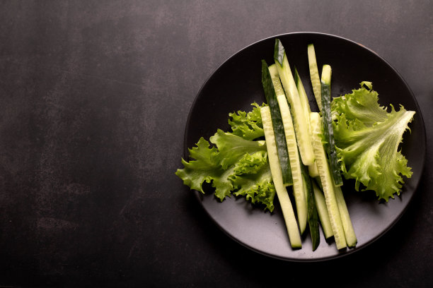 这张孤立的照片突出了一种充满活力的蔬菜沙拉，一种健康成分的绿色混合物。它以脆黄瓜为特色，是营养丰富的素食的完美代表，是那些喜欢节食的人的理想选择。图片下载