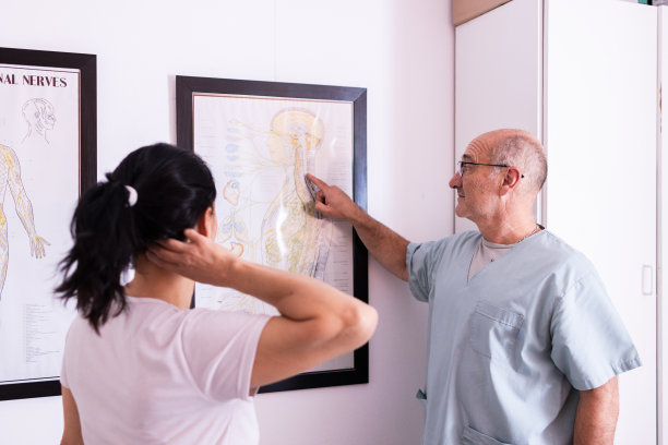 脊椎按摩师正在给他的病人看一张照片，照片上他的脖子有一部分疼痛。图片下载