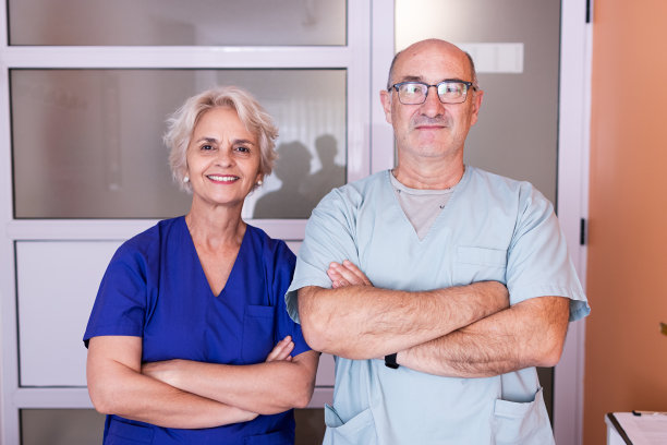 一男一女按摩师在私人诊所里看着镜头的照片。图片下载